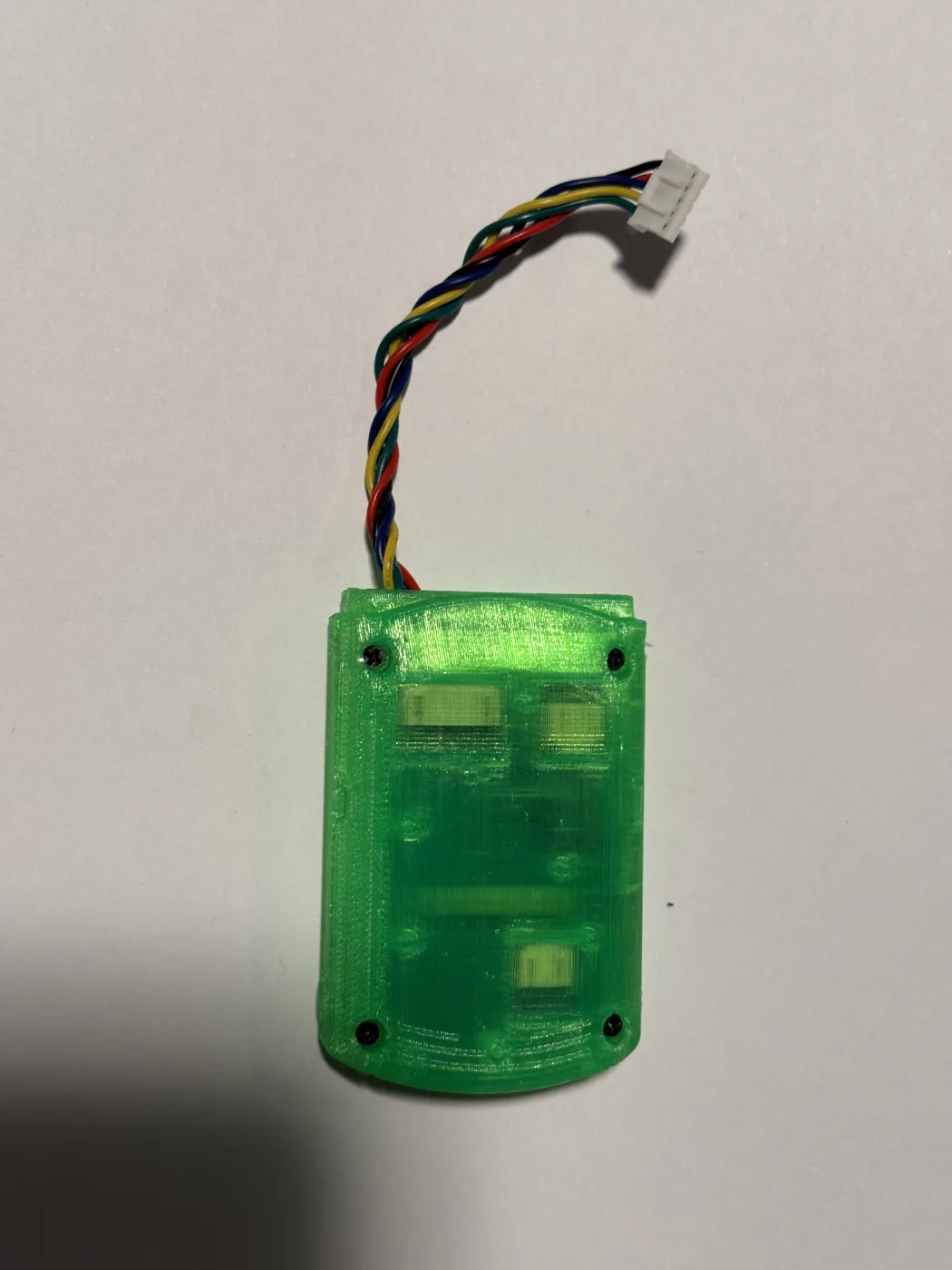 A finished green Pulsar unit on a white surface, its twisted five-wire harness ending in a small white connector