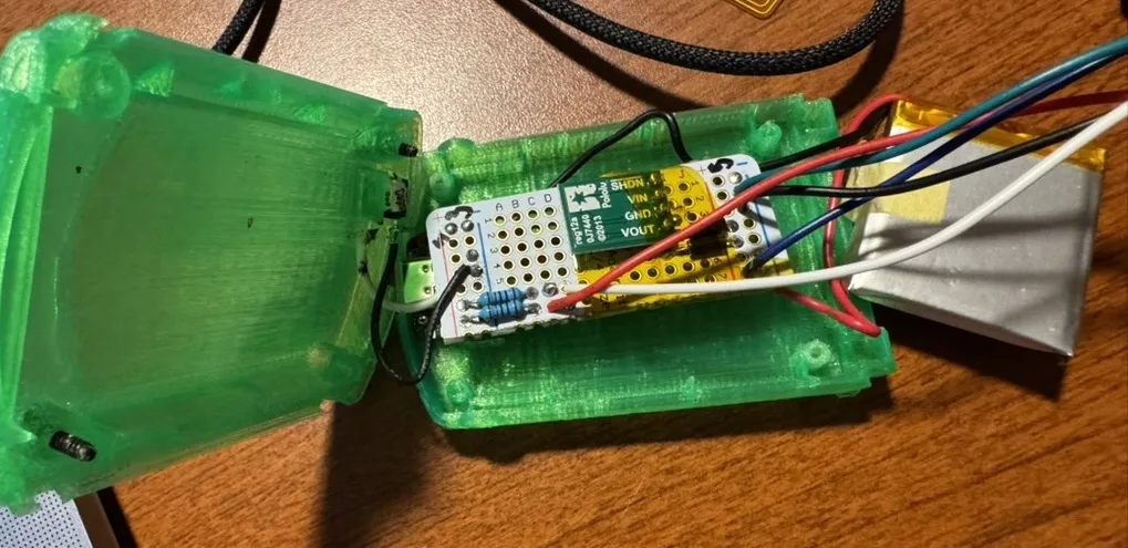 An early green printed shell hinged open, the perfboard build and its wiring sitting in the rear half